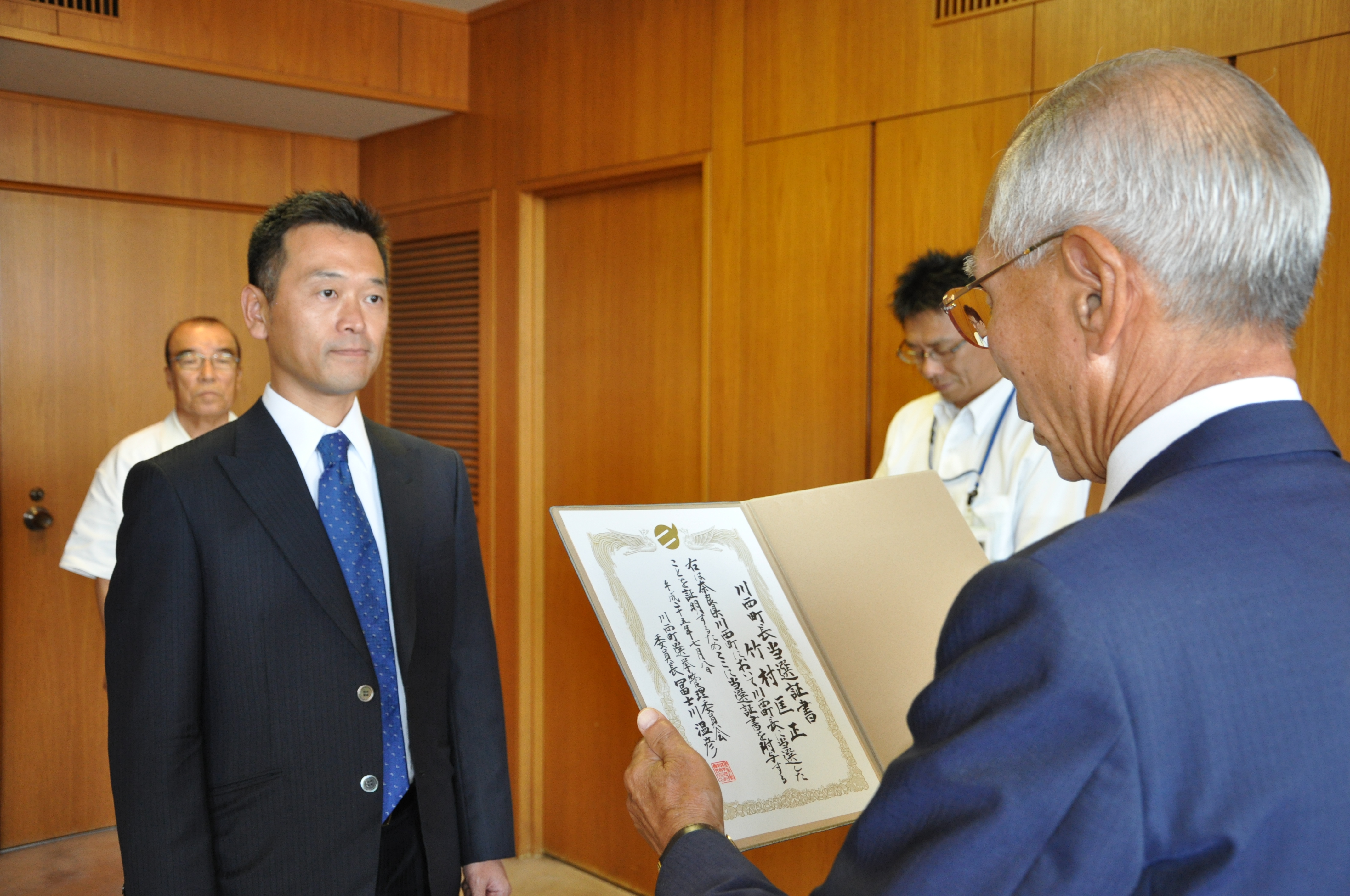 冨士川委員長（写真右）から当選証書を受け取る竹村氏（写真左）