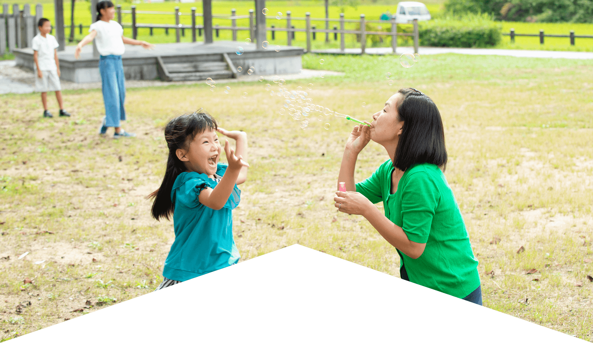 公園で遊ぶ母親と子どもの写真